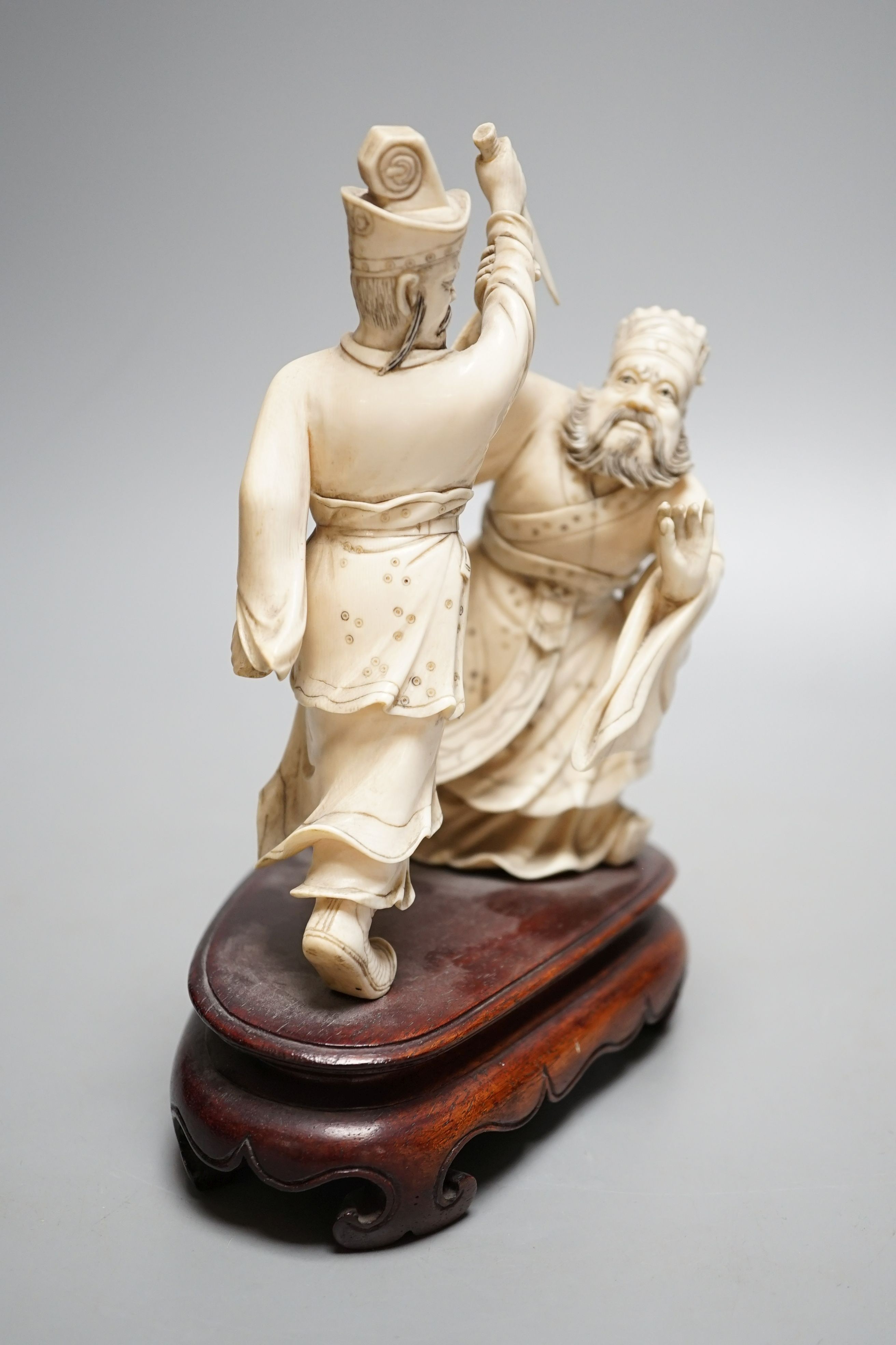 An early 20th century Chinese ivory group of two fighting officials - 21cm tall